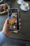 Food Aesthetics - Close-up of a hand holding a smartphone, capturi #16134581