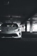 Luxury Cars - White sports car showcased in a dimly lit urban #17793011